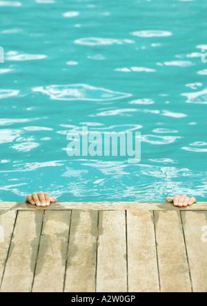 Le mani sul bordo della piscina Foto Stock