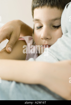 Bambino che dorme con il braccio intorno a madre Foto Stock