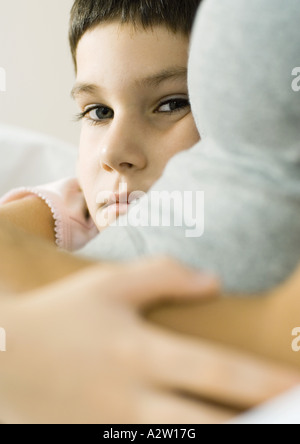 Bambino con braccio intorno a madre Foto Stock