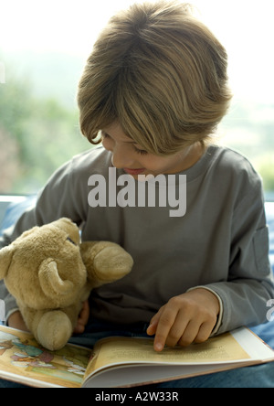 Bambino libro lettura di Teddy bear Foto Stock