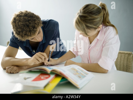 Ragazzo adolescente aiutando amico femmina con i compiti Foto Stock