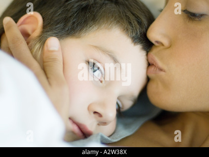 Donna baciare bambino Foto Stock