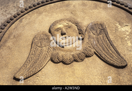 Dettaglio di pietra arenaria in stile georgiano lapide nella calda luce scolpita in stile naif con testa disincarnata e le ali di un angelo Foto Stock