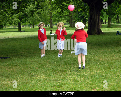 Tre ragazze della scuola giocare a palla nel parco London Inghilterra England Foto Stock