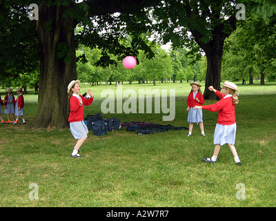 Tre ragazze della scuola giocare a palla nel parco London Inghilterra England Foto Stock