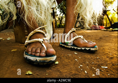 Persone Zulu uomo in abito tradizionale con sandali realizzati dal pneumatico auto Villaggio Culturale di Lesedi vicino a Johannesburg in Sud Africa Foto Stock