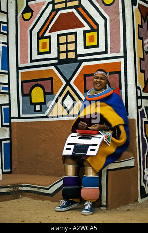 Ndebele donna in costume tradizionale donna sposata geometrico tradizionale dipinti a muro in background in Sud Africa Foto Stock