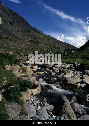 Un flusso che scorre sulle rocce in Honister Pass Near Keswick nel distretto del lago, con il suo suggestivo paesaggio su una giornata d'estate Foto Stock