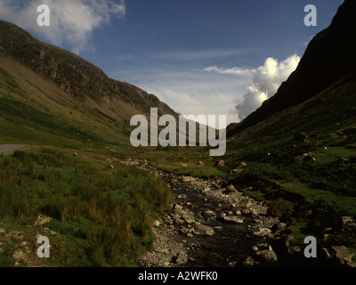 Un flusso che scorre sulle rocce in Honister Pass Near Keswick nel distretto del lago, con il suo suggestivo paesaggio su una giornata d'estate Foto Stock