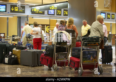 Coda di passeggeri con bagaglio al banco per il check in al Reina Sofia Sur TFS Aeroporto Sud di Tenerife Isole Canarie Spagna Foto Stock