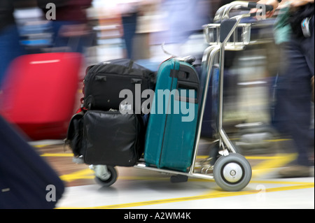 Passeggero maschio spinge i bagagli sul carrello fuori del Reina Sofia Sur TFS Aeroporto Sud di Tenerife Isole Canarie Spagna Foto Stock