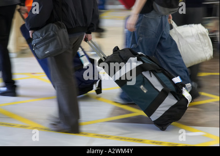Passeggeri tirare Borsoni con ruote al di fuori della Reina Sofia Sur TFS Aeroporto Sud di Tenerife Isole Canarie Spagna Foto Stock