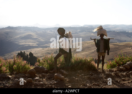 Due uomini tornare indietro a piedi dal mercato di sbarcare in Simien Mountains Etiopia Africa Foto Stock