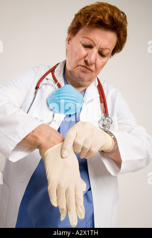 Medico donna mette i guanti. Foto Stock