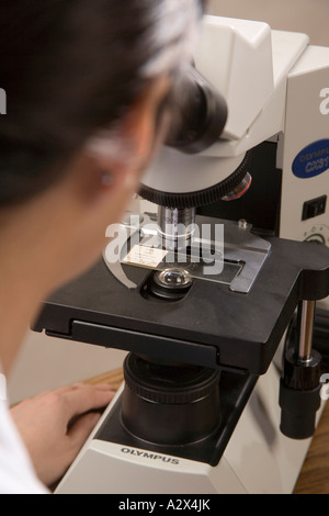 Tecnico di laboratorio utilizza un microscopio. Foto Stock