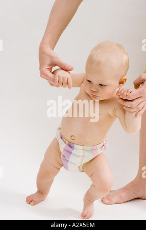 Le pratiche di bambino passeggiate, cercando di prendere i suoi primi passi. Foto Stock