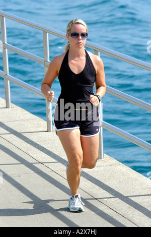 Femmina bionda jogging come parte di un sano esercizio di routine Foto Stock
