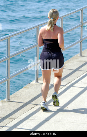 Femmina bionda jogging come parte di un sano esercizio di routine Foto Stock