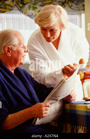 Coppia senior in accappatoi in luoghi chiusi al momento della colazione. Foto Stock