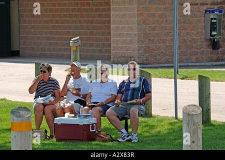 Gruppo di persone anziane siedono all'ombra avente un picnic Foto Stock