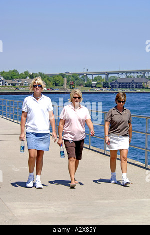 Tre donne teenage camminare insieme in un gruppo Foto Stock