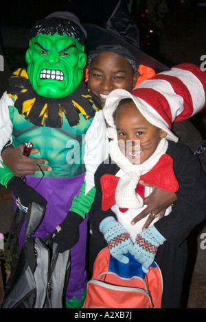 Halloween mom con le braccia intorno al suo incredibile Hulk e Cat in the hat trick or treaters. St Paul Minnesota USA Foto Stock