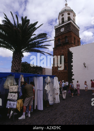 Dh TEGUISE LANZAROTE mercato domenicale di stallo biancheria da strada venditori acquirenti chiesa torre dell orologio Foto Stock