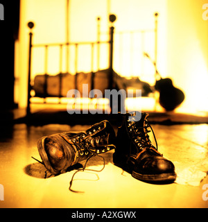 Letto a baldacchino e una chitarra in background con scartato barche di combattimento incandescente in giallo e arancione. Foto Stock