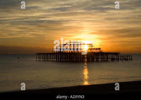 Tramonto sul molo ovest derelict a Brighton Sussex. Bruciato, il molo non raggiunge più la terra. Foto Stock