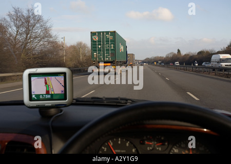 La guida in Inghilterra utilizzando l'originale TomTom GO la navigazione satellitare montato sul cruscotto Foto Stock