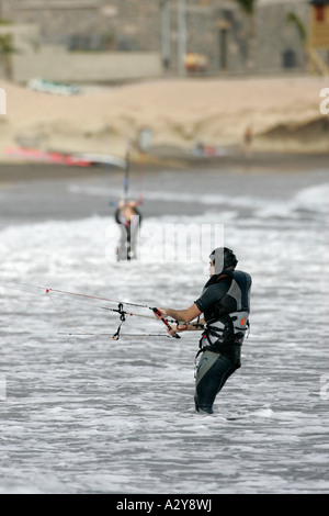 Kitesurfer maschio in muta controlla il kite surf sulla schiuma El Medano beach Tenerife Canarie Spagna Foto Stock