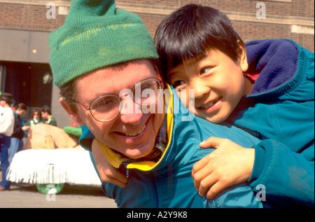 Papà portante figlio asiatici su indietro età 30 e 3. Il giorno di San Patrizio Parade St Paul Minnesota USA Foto Stock