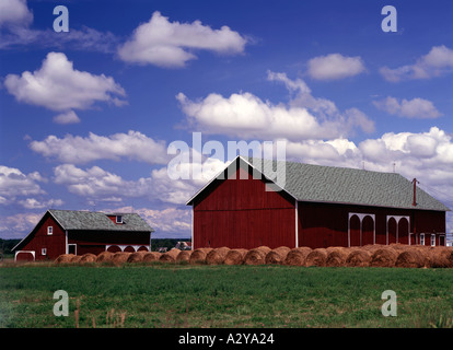 Door County in Wisconsin dove round balle di fieno vengono memorizzati al di fuori di un colorato granaio rosso Foto Stock