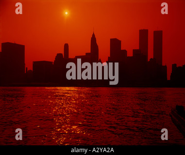 Sunset over inferiore dello skyline di Manhattan a New York visto dal lato Brooklyn dell'East River Foto Stock