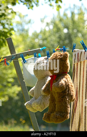 Carino beige e marrone orsacchiotto appeso sulla linea lavanderia a secco Foto Stock