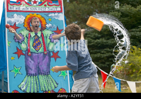 Caucasian 5 anno vecchio ragazzo getta la spugna bagnata a uomo alla piccola città del 4 luglio festival Foto Stock