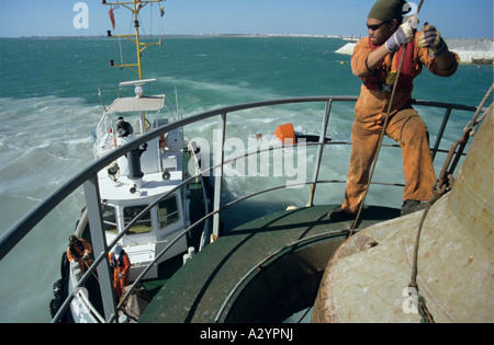 Membro di equipaggio sulla prua di una draga Porto di Manama Bahrain Foto Stock