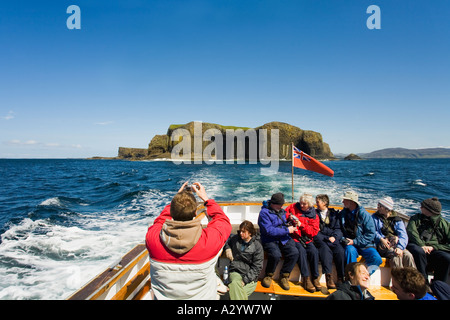 Isola di Staffa presa dal piacere Turistiche Gita in barca di isola in estate il sole al sole con cielo blu e i passeggeri interno di Argyll Foto Stock
