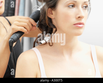 Modello avente i suoi capelli arricciati Foto Stock