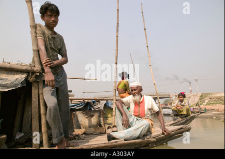 Un nonno e il nipote rilassante sulla loro serpente incantatore barca Bangladesh Foto Stock
