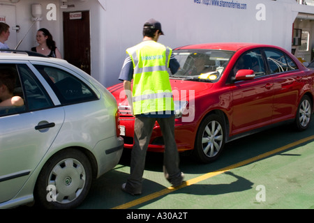 Traghetto per auto, nella contea di Kerry, Irlanda. L'uomo parcheggio auto. Foto Stock