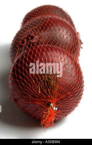 Le cipolle rosse in borse di maglia contro il bianco di sfondo per studio Foto Stock