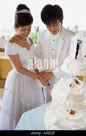 Sposa e lo sposo il taglio di torta di nozze Foto Stock