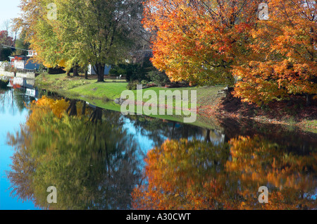 Autunno aceri e Willow si riflette ancora in un fiume in Estrie Quebec Foto Stock