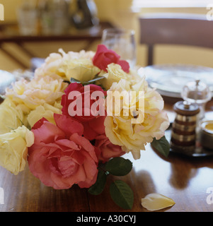 Tagliare rosa e crema di teste di rose sul tavolo da pranzo in legno Foto Stock