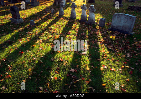 Forti ombre da quattro a forma di croce le lapidi in un cimitero di Farnham Estrie Quebec Foto Stock