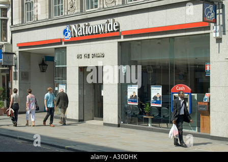 Finestre anteriori e ingresso ai locali delle filiali della Nationwide Building Society persone che passano il buco nel bancomat della parete The Strand London England UK Foto Stock