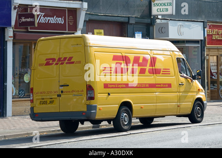 DHL di consegna pacchi van parcheggiato in tipici negozi di High Street Foto Stock