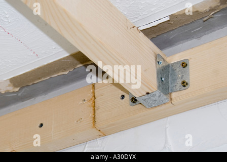 In acciaio zincato stampato la staffa di metallo utilizzato per rendere la falegnameria giunto tra travi del soffitto e piastra a parete per interni home improvement alterazioni REGNO UNITO Foto Stock