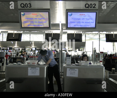 "Avviso passeggero con armi da fuoco si prega di avvisare il personale della compagnia aerea al momento del check-in Counter' Foto Stock